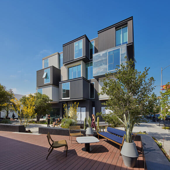 Modern building with geometric design and outdoor seating area.